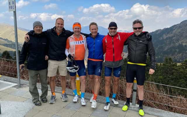 Group of cyclists at the summit of Wuling Pass in Taiwan
