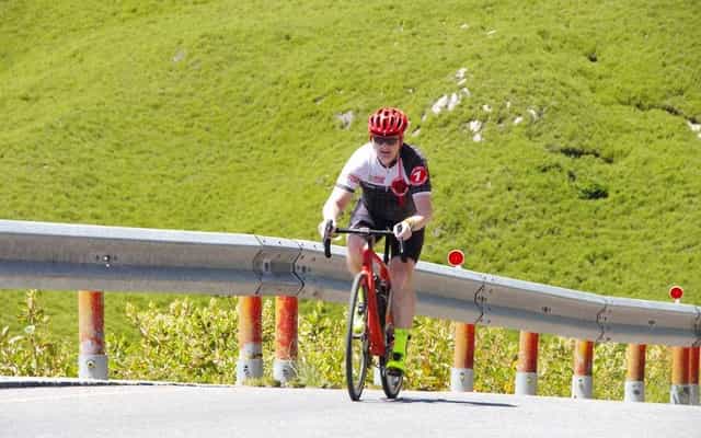 Cyclist climbing through alpine grassland near Hehuanshan, Taiwan