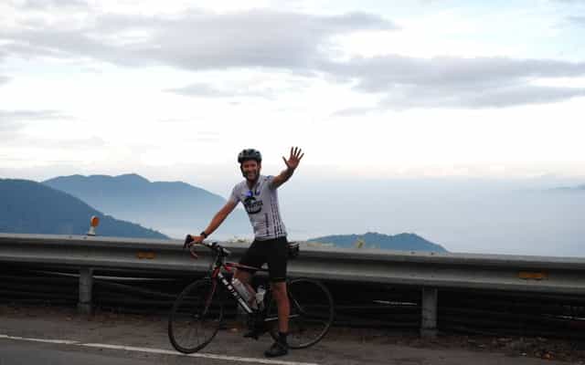Cyclist waving above the clouds on Taiwan's KOM mountain road