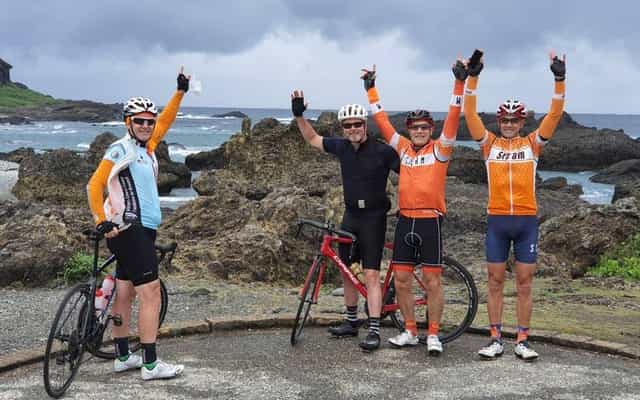 Four cyclists celebrating at Sanxiantai on Taiwan's east coast