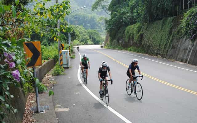 Two cyclists riding a mountain road near Pinglin, Taiwan