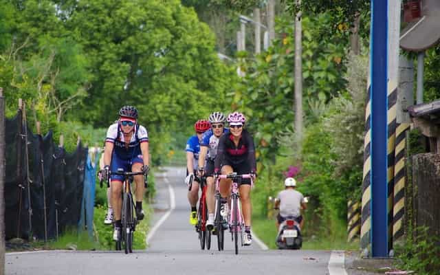 Group of cyclists riding through a quiet rural village in Taiwan