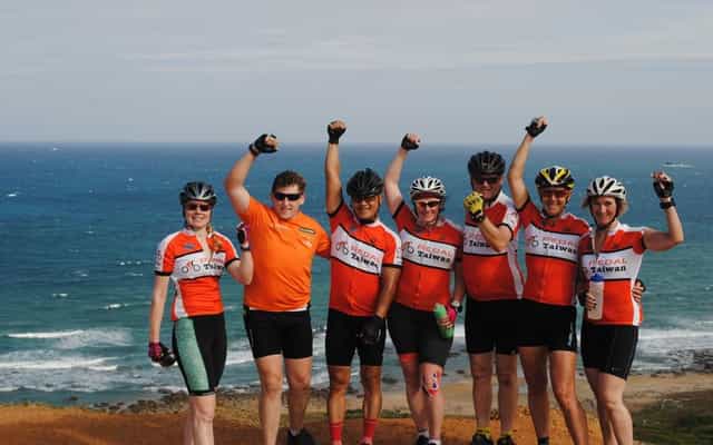 Pedal Taiwan cycling group celebrating at Eluanbi, the southernmost point of Taiwan