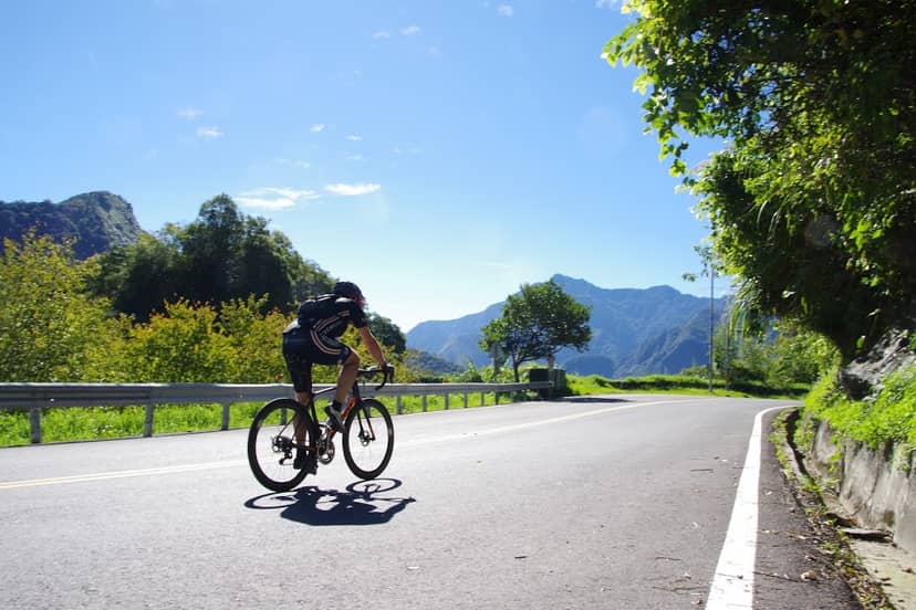 Lone cyclist on a wide mountain road in bright sunshine, perfect autumn cycling conditions in Taiwan
