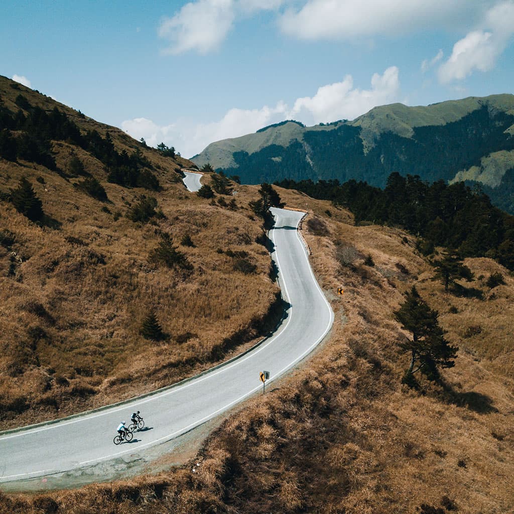 Aerial view of cyclists on the winding alpine road near the summit of the Taiwan KOM, Wuling Pass