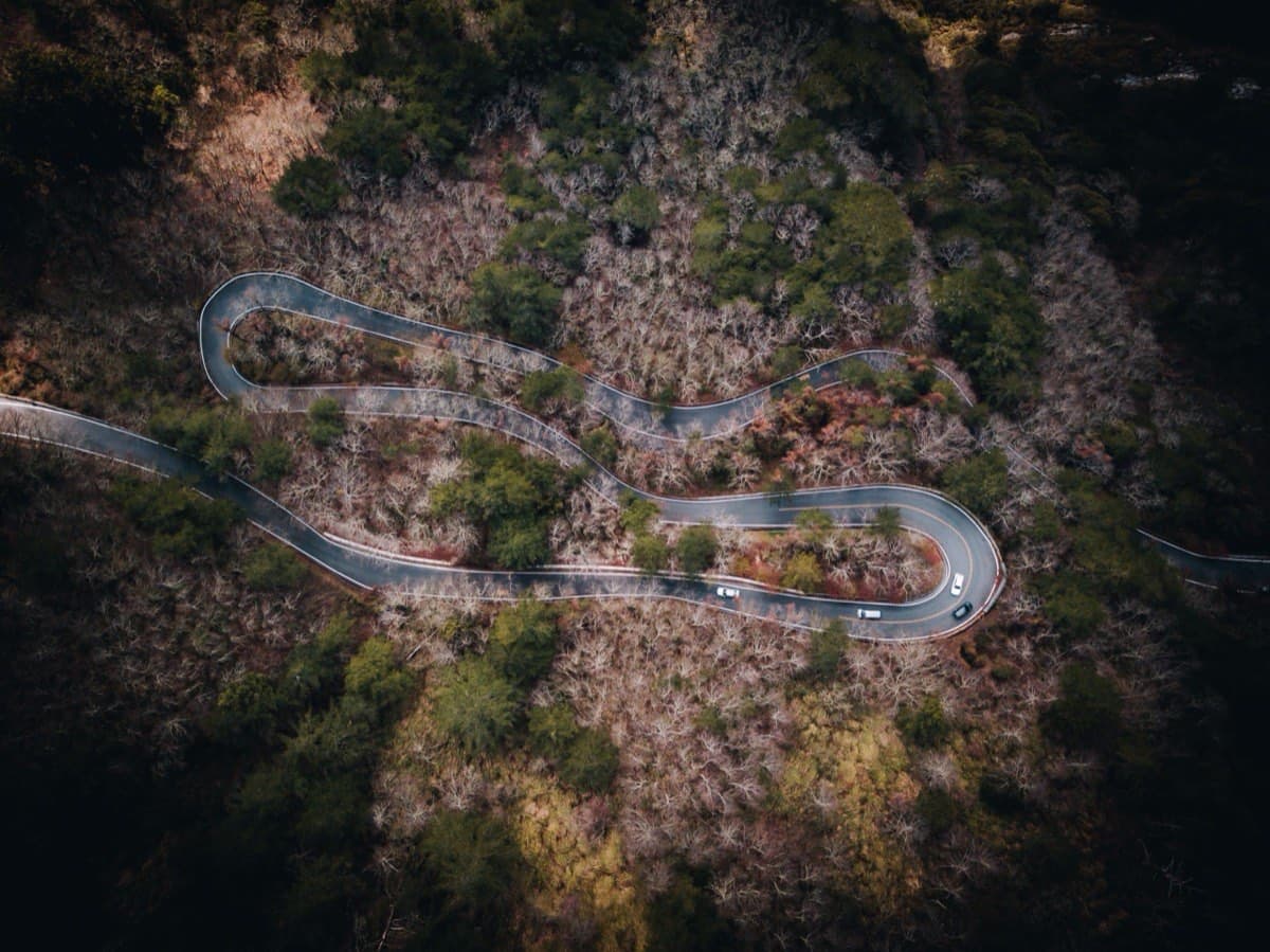 Aerial view of a winding mountain switchback road through forested terrain in central Taiwan