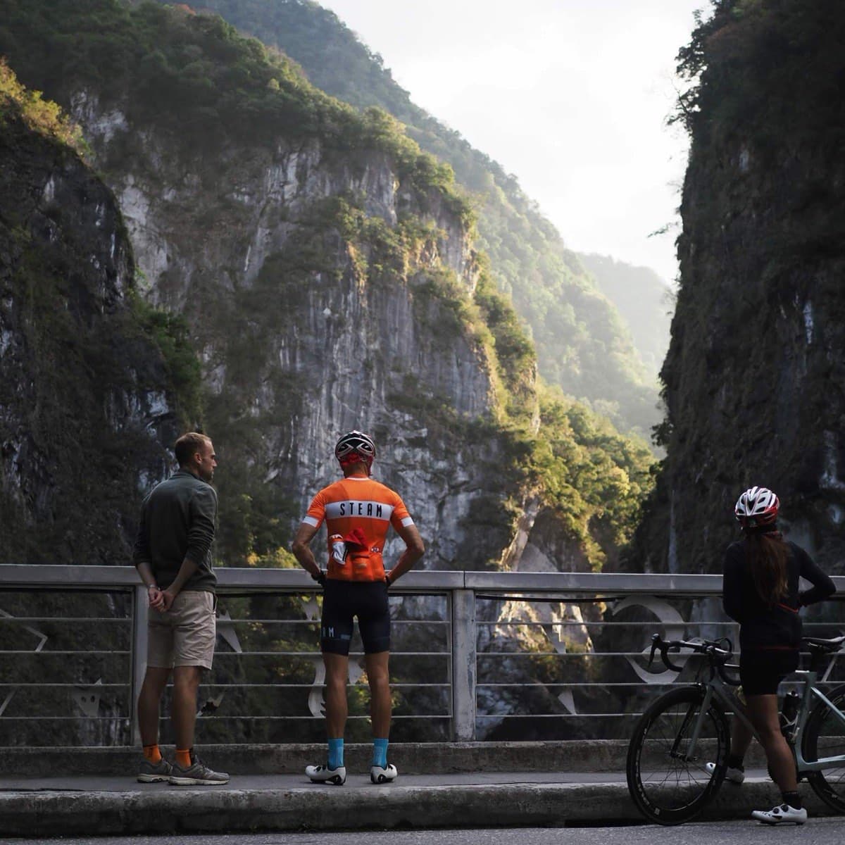 Cyclists pausing on a bridge to take in the towering marble walls of Taroko Gorge