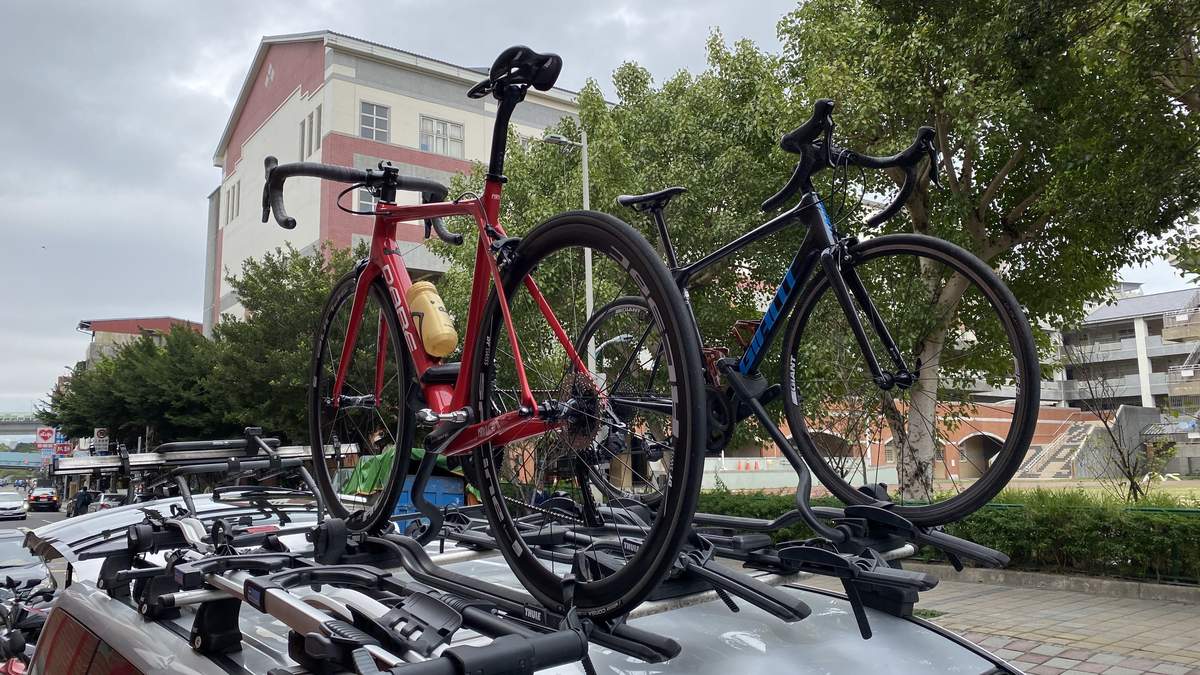 Road bikes mounted on the roof rack of a support vehicle at a Taiwan town stop