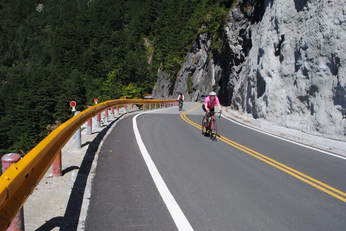 Cyclist climbing through cloud forest on the Taiwan KOM route above Tianxiang, a road originally built by Japanese engineers in the colonial era